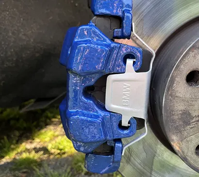 Modrý brzdový třmen BMW M s vrtaným kotoučem