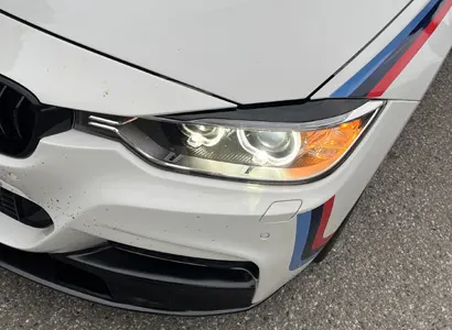 Detail světlometu bílého BMW s M polepy